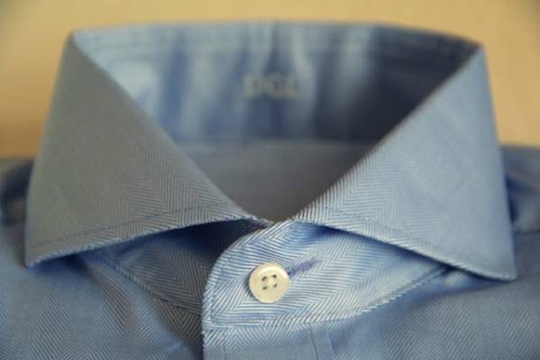 Close up of a top button of a blue shirt