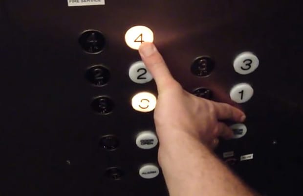 close up of a person pushing the button on an elevator