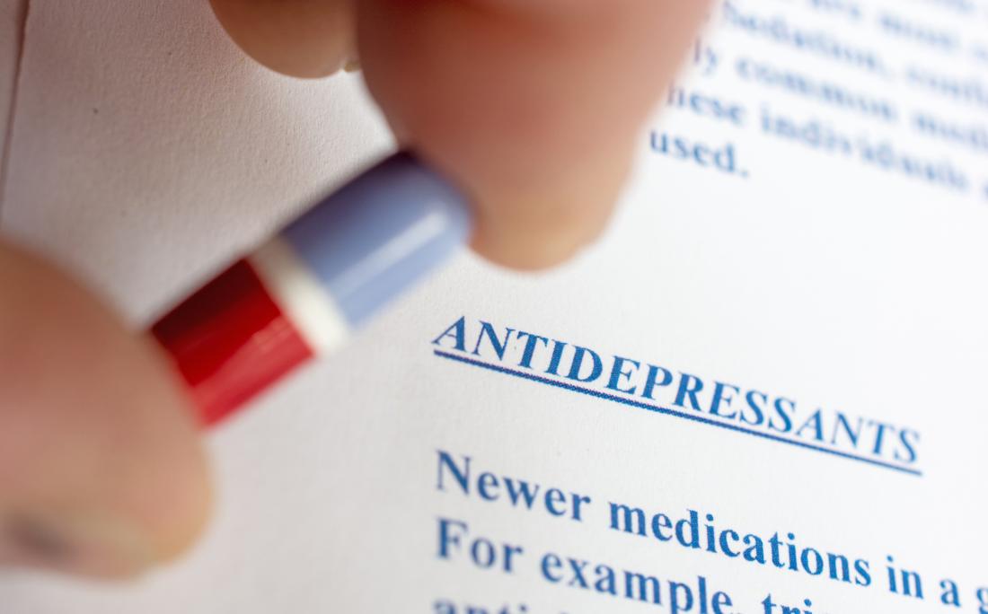 a description of antidepressants and a person holding a pill